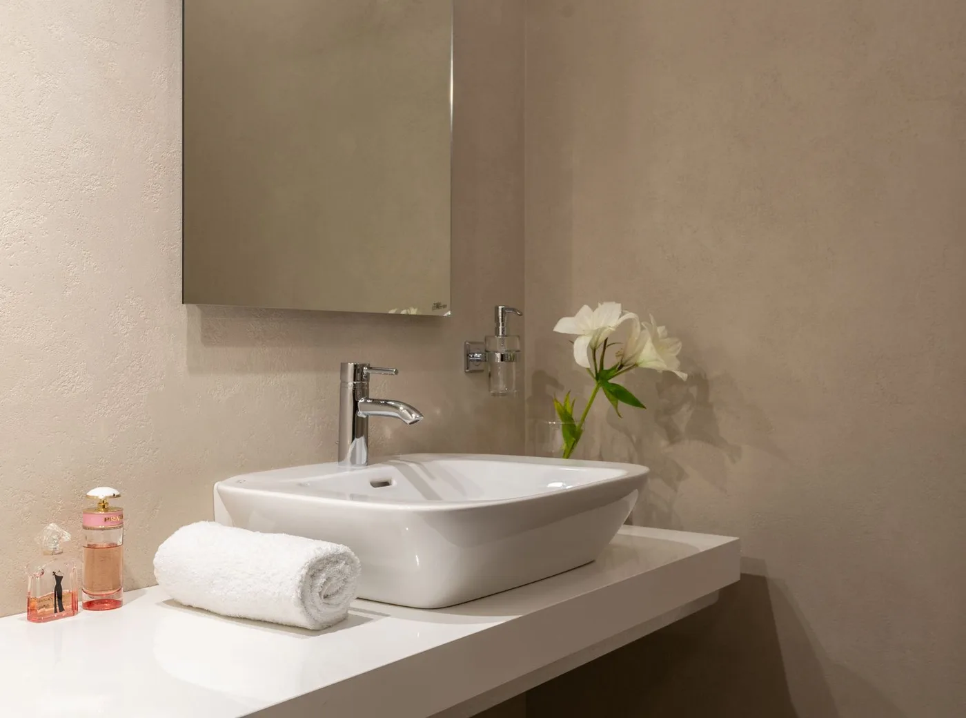 A bathroom vanity with mirror and a hand towel
