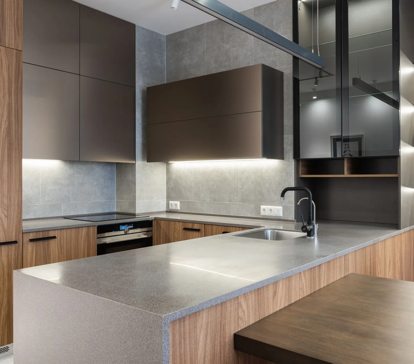 A kitchen sink set into a counter beside wooden cabinets