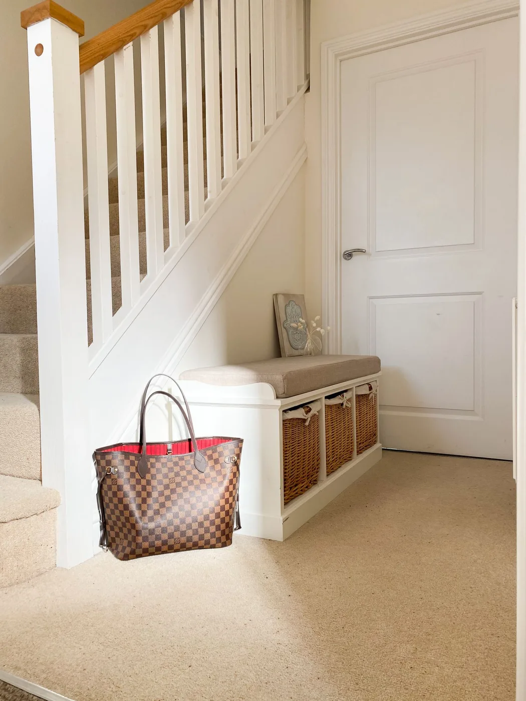 A storage bench and wicker basket beside a staircase